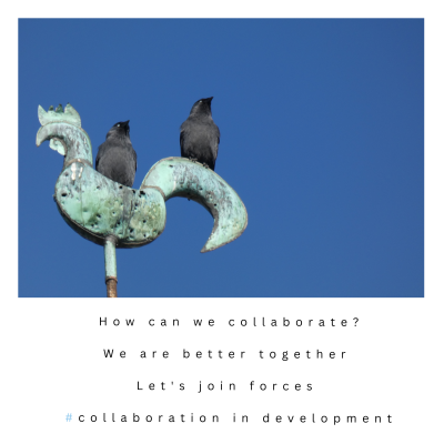 Two jackdaws on a cockerel shaped weather vane against a deep blue sky