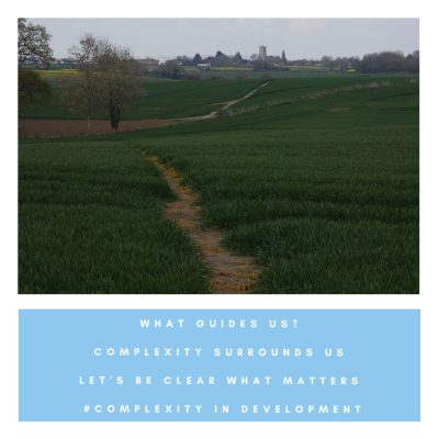 A well-worn path leads through fields of fast-growing crops Down into a valley and then up towards the village Where a flock of houses huddle round a patient church