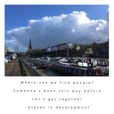 A heavy cloud rears up over a harbourside with blue sky behind